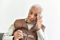 an older man having eye strain from presbyopia
