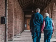 two older adults walking down a hallway