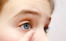 an image of a girl putting on contact lens