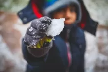 an image of a kid hold up some snow